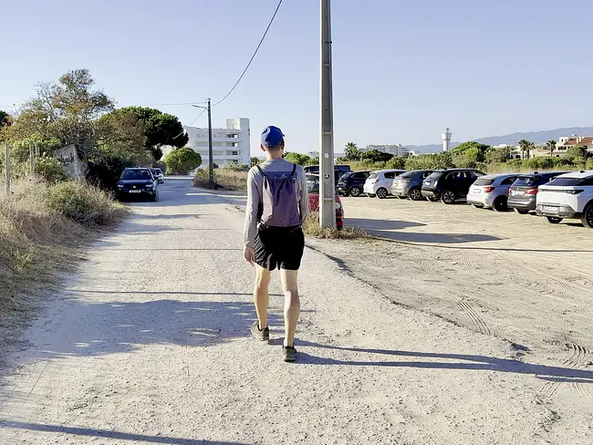 Andy walking past Parking at Praia do Submarino