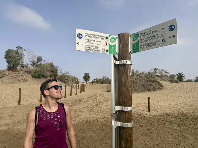 Andy with Directional Signs at Maspalomas Nude Beach