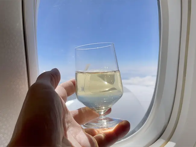 Andy holding glass of white wine on Air France 777 Business Class