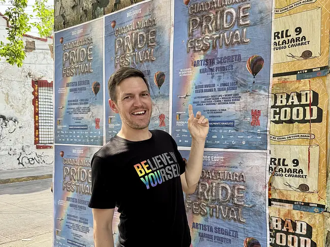 Andy pointing at the Guadalajara Pride Festival sign