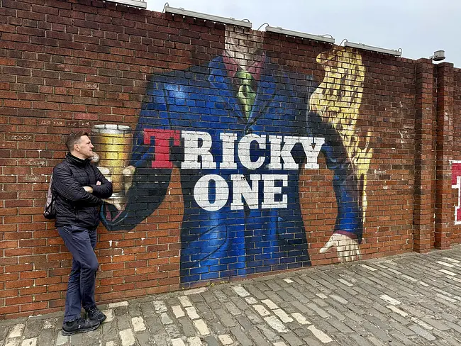 Andy at Tennent's Brewery Tour beside one of the brewery murals